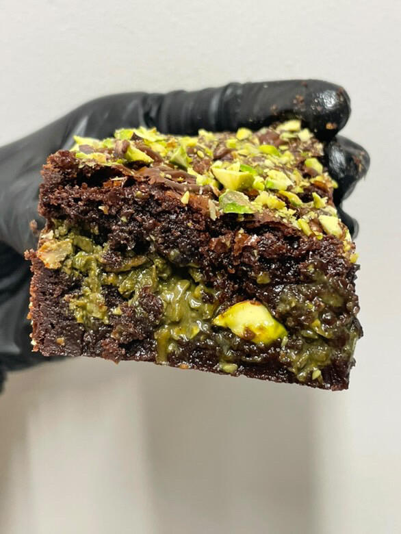 Hand holding dubai chocolate brownie in a cafe in tokyo